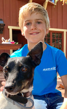 Front view of boy outside with his dog wearing the comfortable crewneck blue cotton Kids Short Sleeve Tee